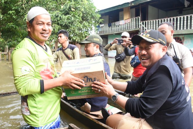 
					Bupati Kampar H. Catur Sugeng Susanto, SH menggunakan sampan saat memberikan bantuan dan meninjau korban banjir.