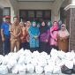 Tim Penggerak PKK Kabupaten Kampar dan rombongan memberikan bantuan kepada warga yang terkena banjir.