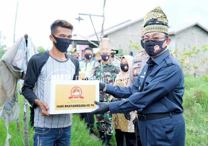 
					Bupati Indragiri Hilir (Inhil), Drs HM Wardan MP saat menyerahkan bantuan
